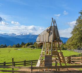 Large wooden playground structure shaped like a horse's head on a meadow with mountain views.