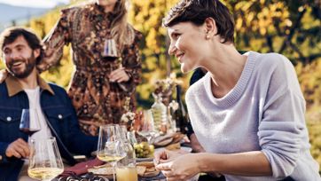 Drei Personen beim Törggelen im Freien